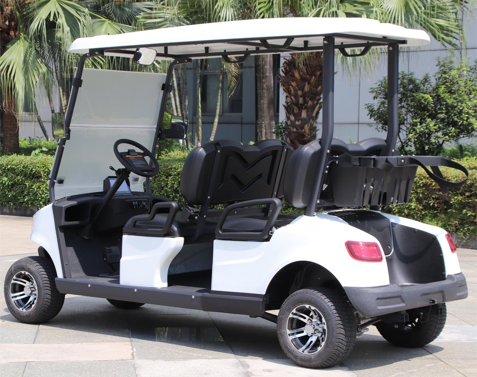Side view of the white 4 seater electric golf buggy showing the two forward facing benches and the bag rack