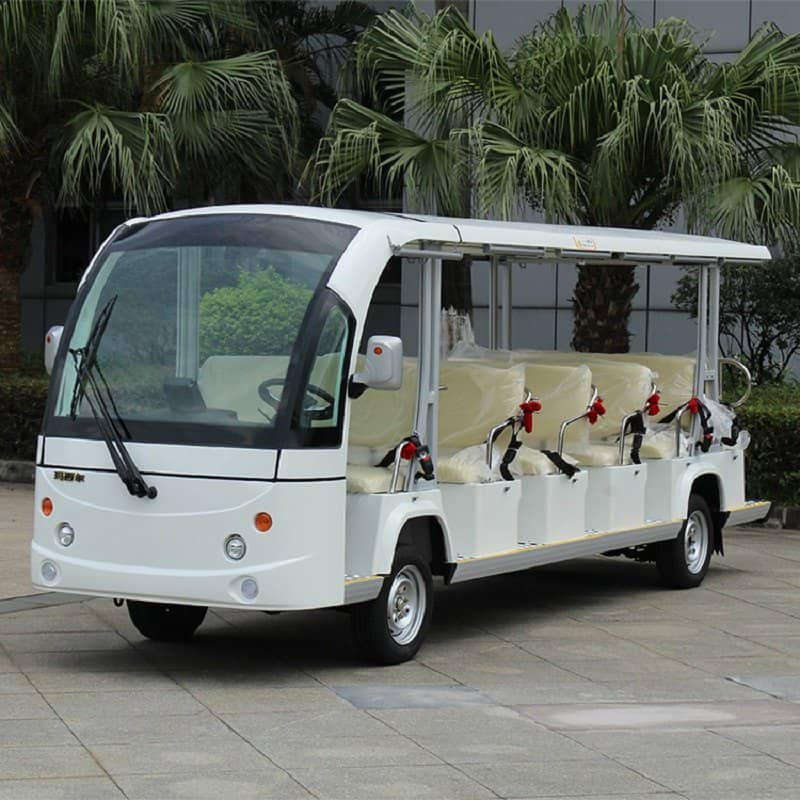 White 17 seat electric shuttle bus with an enclosed cab and a long open body