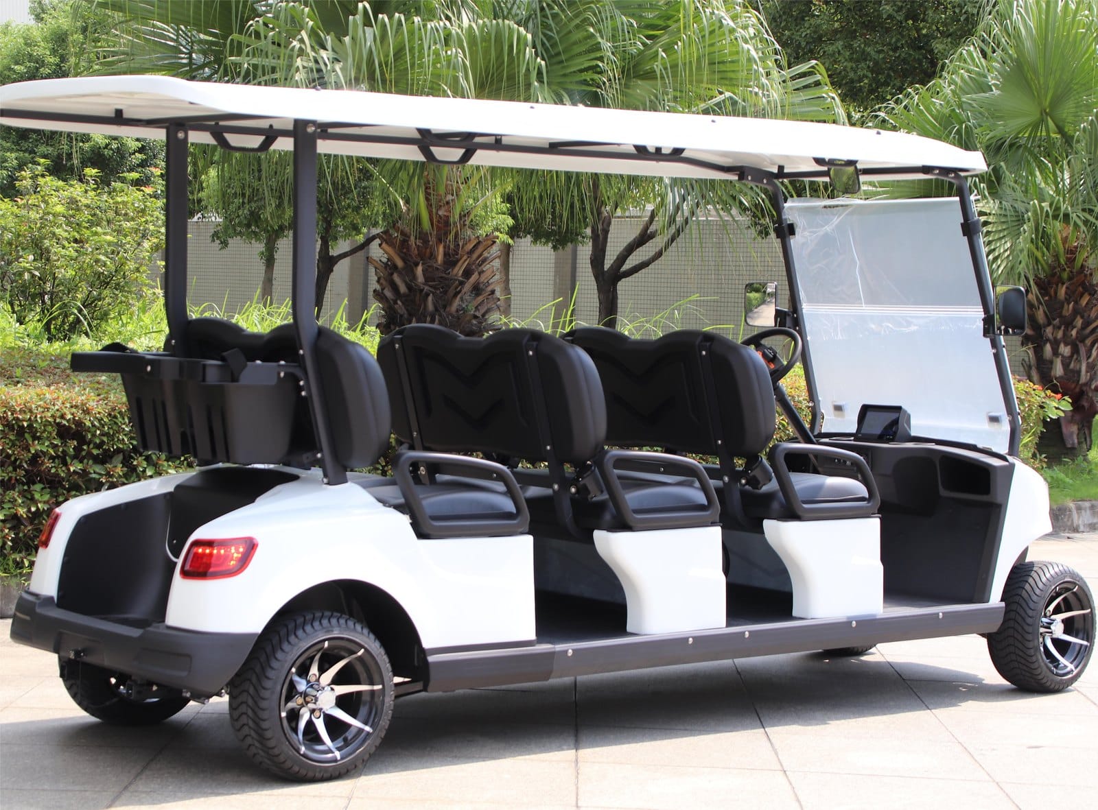 Side view of the white 6 seater electric golf buggy, showing the extended chassis and rear luggage basket