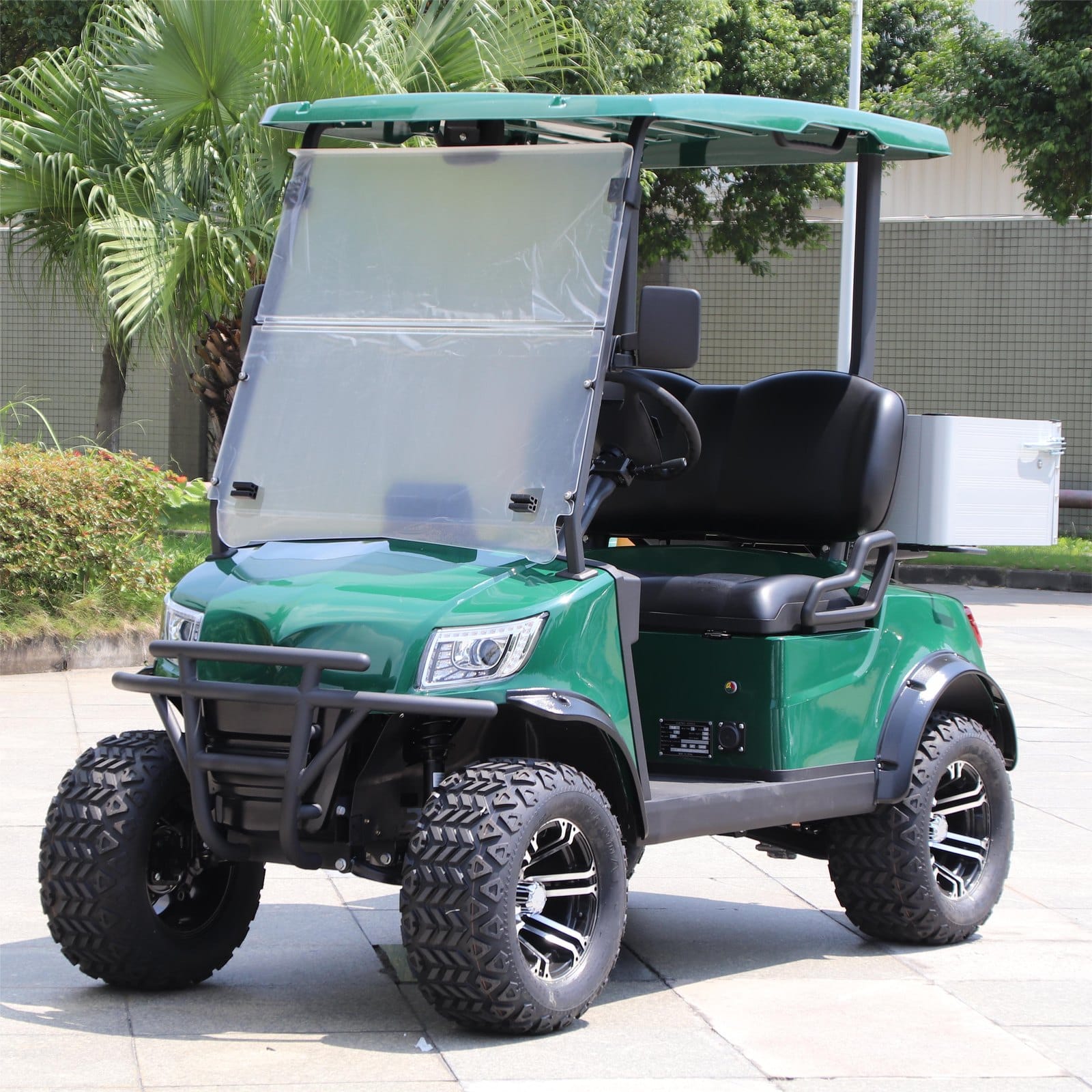 Dark green lifted 2 seater golf buggy outdoors, showing the front protection bar and knobbly all terrain tyres